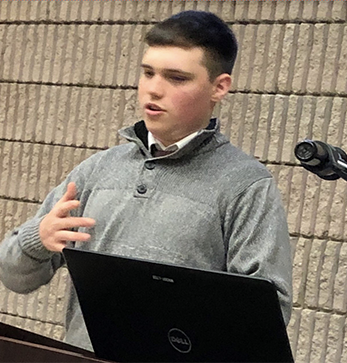 Dante Petruzziello speaks at podium during academic convivium